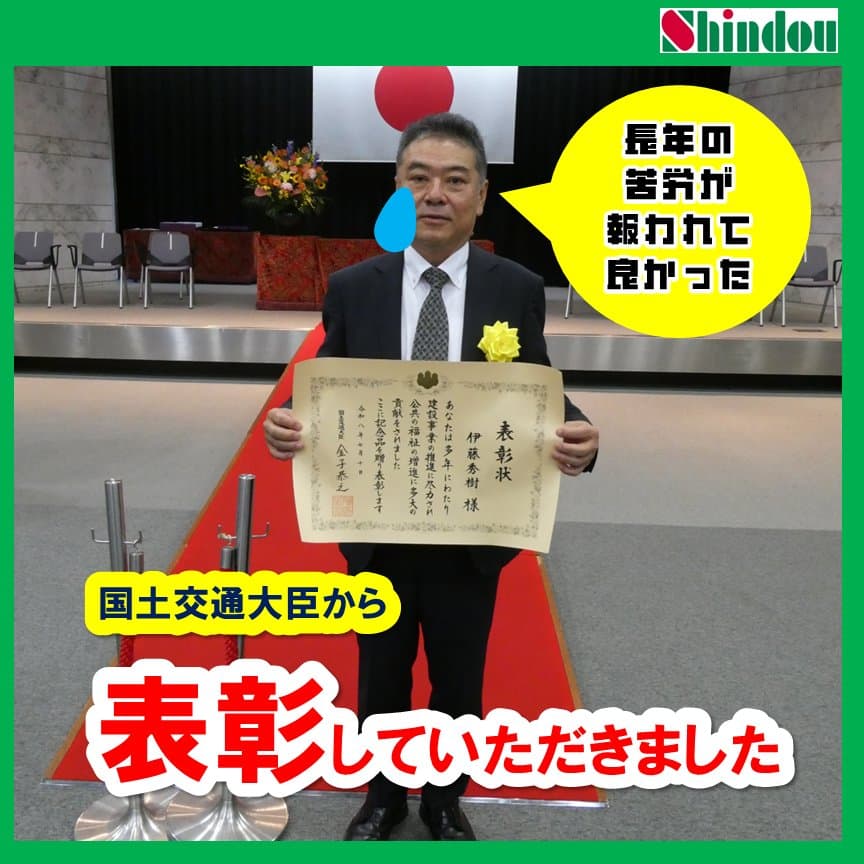 国土交通大臣表彰の表彰状を手に記念撮影する信藤建設 代表取締役 伊藤秀樹